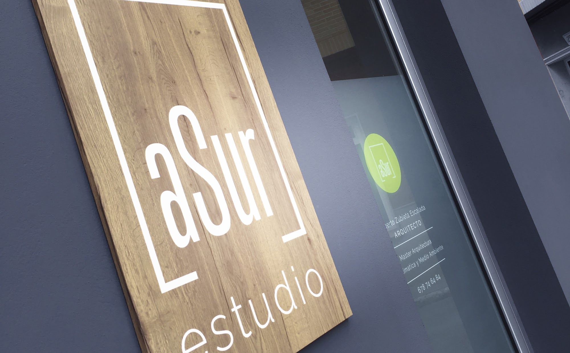 Rótulo de roble de aSur estudio en la fachada gris del estudio